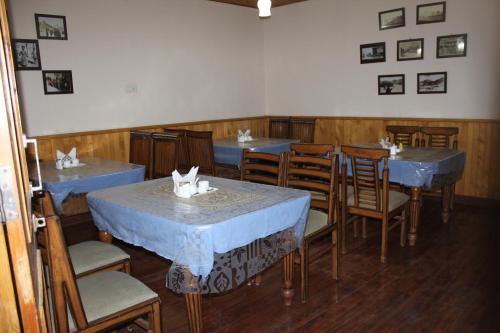 a dining room with blue tables and chairs at New Royal Guest House in Leh