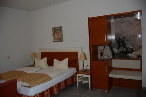 a hotel room with a bed and a dresser with a mirror at Alpina home in Rosenheim