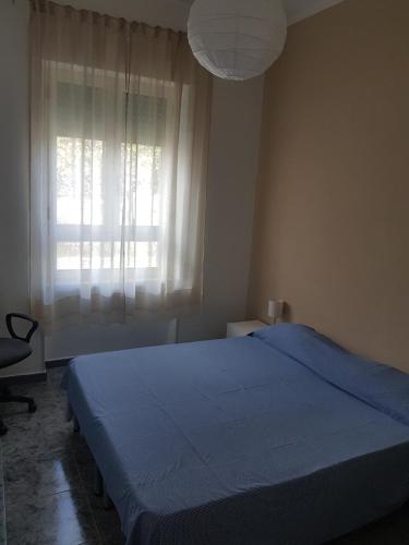 a bedroom with a blue bed and a window at Casa Marcella in Cetraro
