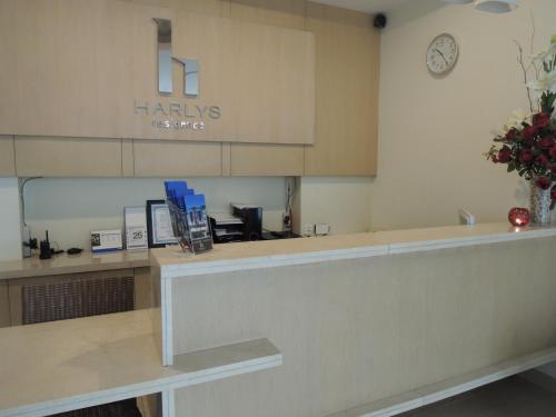 a waiting room with a counter and a clock on the wall at Harlys Residence in Jakarta