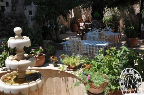 a fountain in the middle of a garden with potted plants at Sibel Hotel in Antalya