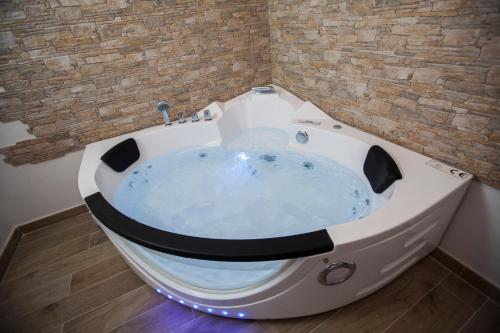 a jacuzzi tub in a room with a brick wall at Villa hortencia in Tarragona