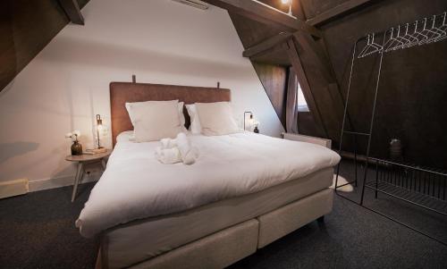 ein Schlafzimmer mit einem großen Bett mit zwei Teddybären darauf in der Unterkunft HUISJES AAN DE AMSTEL - Your home away from home in Amstelveen