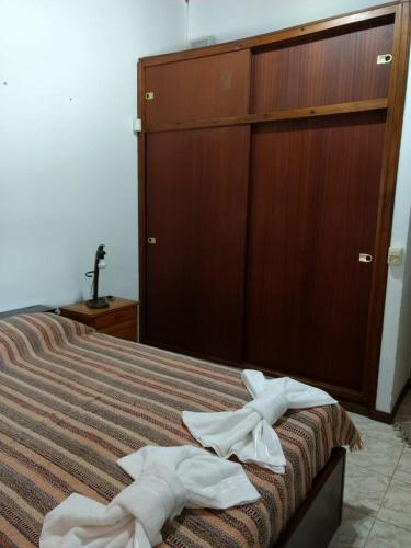 a bedroom with a bed with two towels on it at QUINTA EN OPEN DOOR-LUJÁN in Luján