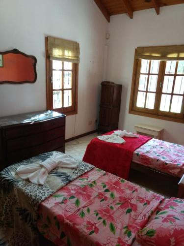 a bedroom with two beds and a dresser and windows at QUINTA EN OPEN DOOR-LUJÁN in Luján