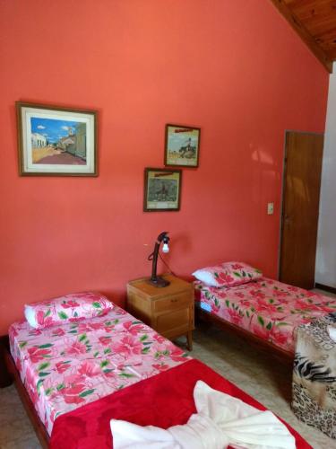 two beds in a room with red walls at QUINTA EN OPEN DOOR-LUJÁN in Luján