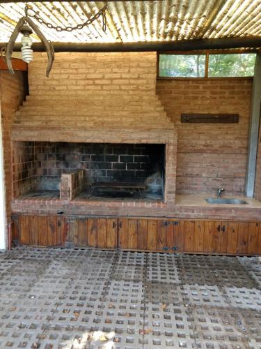 a brick fireplace in a room with a sink at QUINTA EN OPEN DOOR-LUJÁN in Luján