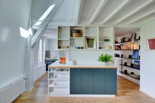 une cuisine avec des placards bleus et des étagères blanches dans l'établissement L'Etoilé, à Bordeaux