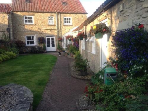 a house with a dog walking down a walkway at Stilworth House in Helmsley