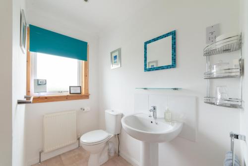 Baño blanco con aseo y lavamanos en No. Three, en Stornoway