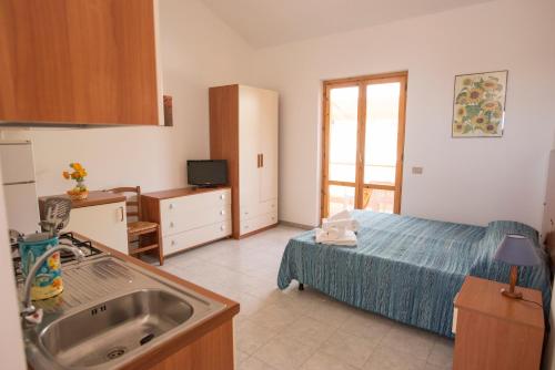 una cucina con letto e lavandino in una camera di Studio 200 meters from the sea, wifi, self catering a Case San Marco