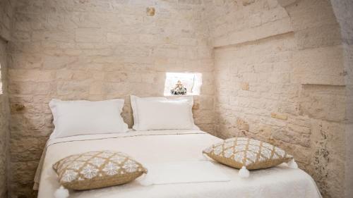 a bedroom with two beds with white sheets and pillows at Astra in Alberobello