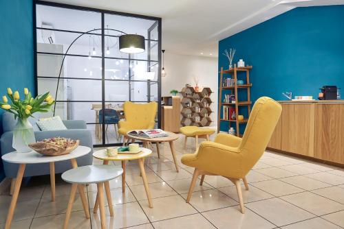 uma sala de estar com cadeiras amarelas e uma parede azul em Residence Leopoldo em Florença
