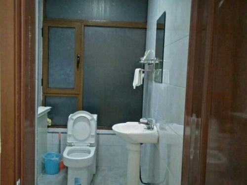 a bathroom with a toilet and a sink at Xinming Fashion Hotel in Yanji