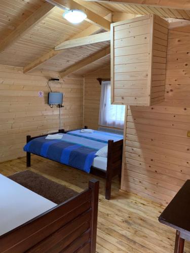 a bedroom with a bed in a wooden room at Casutele Suhardul Mic in Lacu Rosu