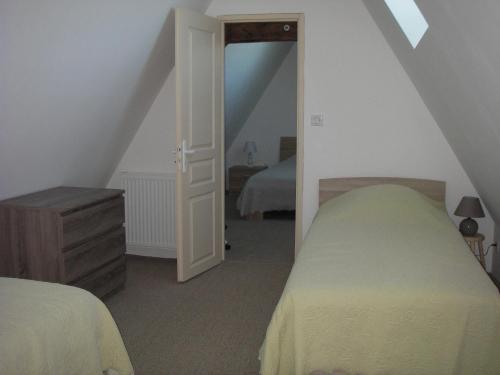 a attic bedroom with two beds and a doorway at Les 4 Saisons in Sarlat-la-Canéda