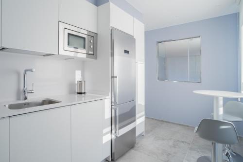 a white kitchen with a refrigerator and a sink at GOXUE HOME in San Sebastián