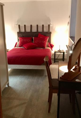 un lit rouge avec des oreillers rouges dans une chambre dans l'établissement l’Atelier, à Sélestat
