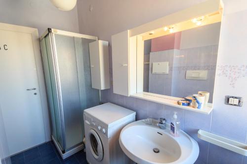 La salle de bains est pourvue d'un lavabo, de toilettes et d'un miroir. dans l'établissement Ampio appartamento con Box auto, à Celle Ligure