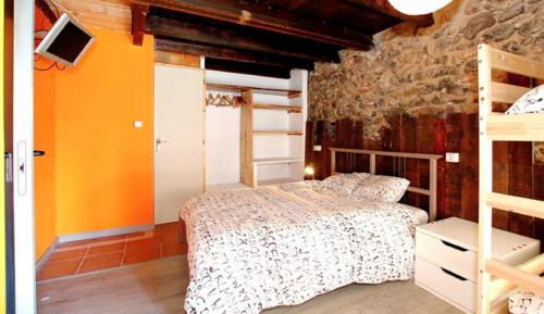 a bedroom with a bed and a brick wall at La Calma de Bellver in Bellver de Cerdanya 