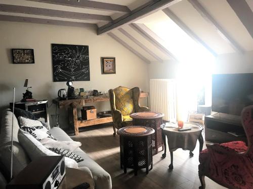 ein Wohnzimmer mit Sofas, Stühlen und einem Tisch in der Unterkunft La Roseraie in Sentheim