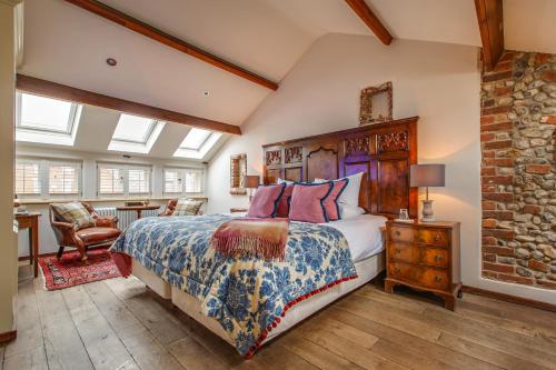 a bedroom with a bed and a brick wall at Byfords in Holt