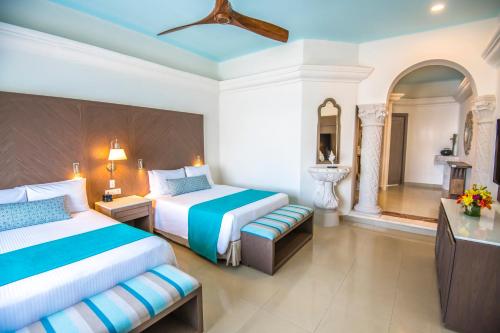 a hotel room with two beds and a bathroom at Wyndham Alltra Playa del Carmen Adults Only All Inclusive in Playa del Carmen