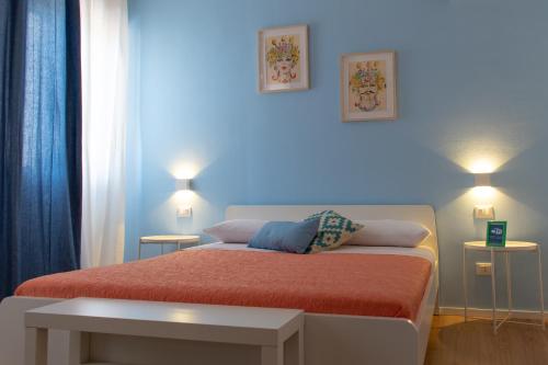 a bedroom with a bed with two lights on at Mondello Beach Rooms - by the sea in Mondello