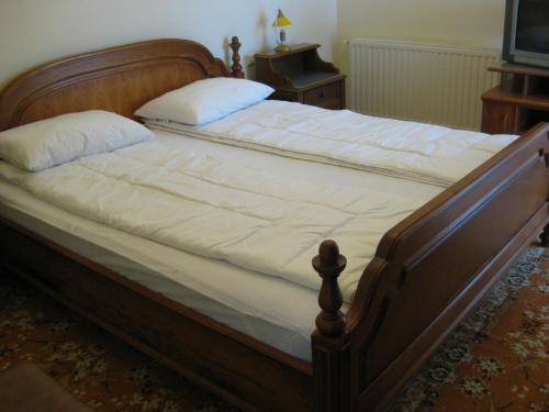 un letto con struttura in legno e lenzuola bianche di V3 Villa a Eforie Nord