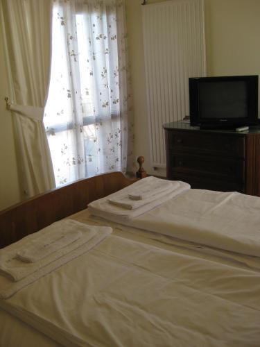 a bedroom with a bed and a tv and a window at V3 Villa in Eforie Nord