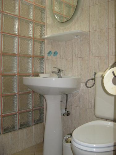 a bathroom with a sink and a toilet and a mirror at V3 Villa in Eforie Nord