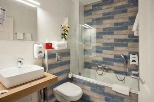 a bathroom with a toilet and a sink and a shower at Le Neptune & Spa in Propriano