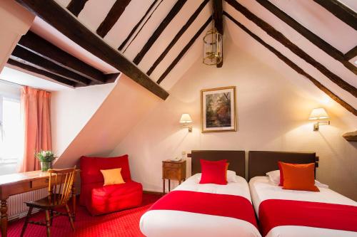 a attic room with two beds and a desk at Hôtel Saint Roch in Paris