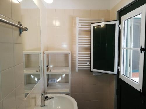 a bathroom with a sink and a mirror and a window at Casa Típica Algarvia in Cabanas de Tavira