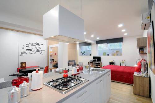 a kitchen and living room with a red couch at Folco Studio Apartment in Piazza Armerina