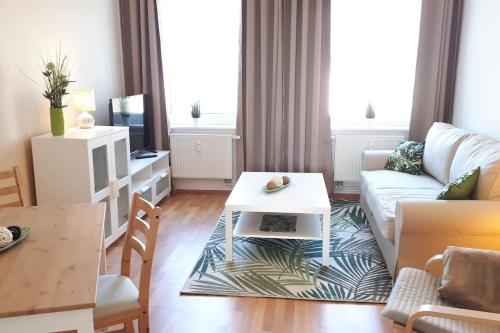 ein Wohnzimmer mit einem Sofa und einem Tisch in der Unterkunft Ferienwohnung mit Seeblick in Brandenburg an der Havel
