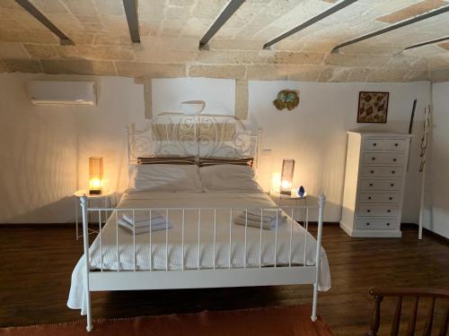 a white bed in a room with two lamps at Buon Consiglio B&B in Lecce