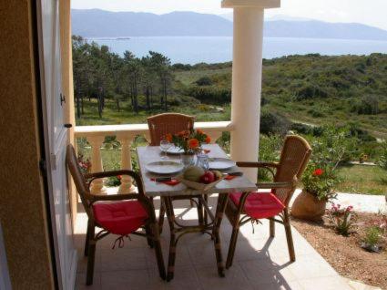 a table and chairs on a balcony with a view at Villa Liamone Studio für 3 Personen , 400 m vom Strand, Pool, Klimaanlage in Sagone