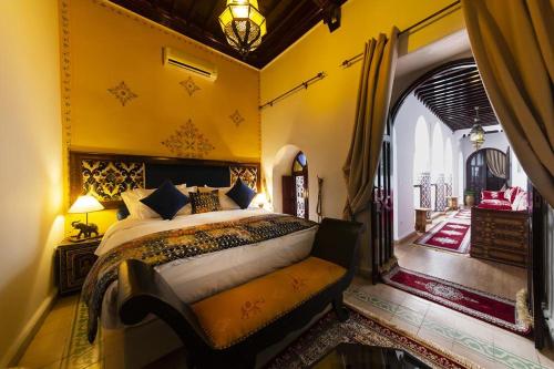 Schlafzimmer mit einem Kingsize-Bett und einem Torbogen in der Unterkunft Riad Maison Belbaraka in Marrakesch