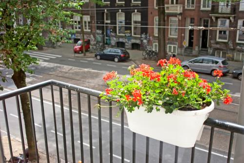 a pot of flowers hanging from a rail on a balcony at Hotel Allure in Amsterdam