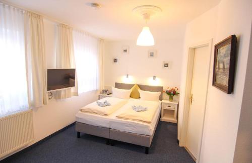 1 dormitorio con 1 cama y TV en Kapitaenshaus-Lassen-Zimmer-Mayflower, en Westerland