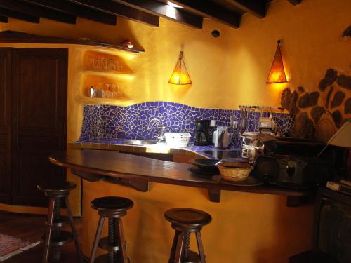 eine Bar mit Hockern in einer Küche mit blauen Fliesen in der Unterkunft Casa Niro in Tías