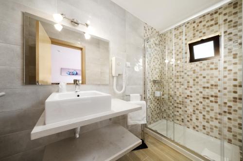 een badkamer met een wastafel en een douche bij Quinta das Andorinhas in Carvoeiro