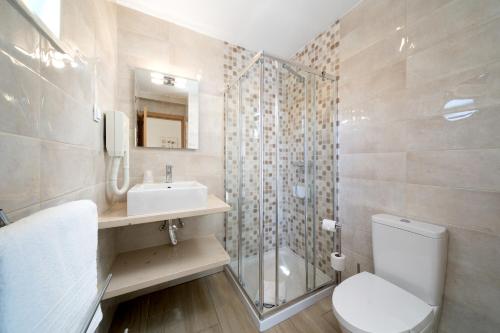 a bathroom with a toilet and a sink and a shower at Quinta das Andorinhas in Carvoeiro