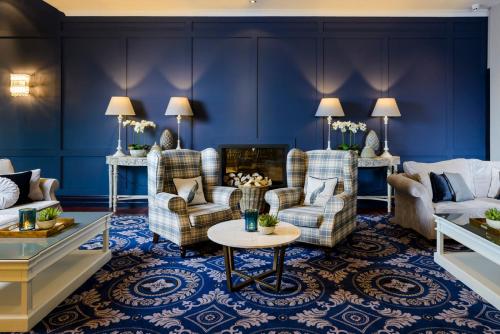 a living room with blue walls and couches and a table at Shearwater Hotel & Spa in Ballinasloe