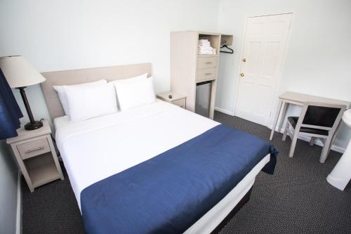a bedroom with a large bed with a blue blanket at Ocean Park Hotel in Los Angeles