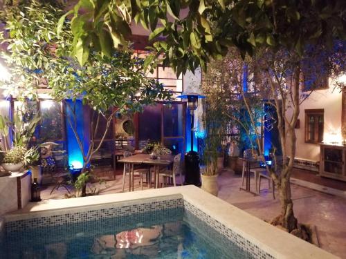 a pool in a room with trees and a table at Les Bains de Fez Tara in Fès