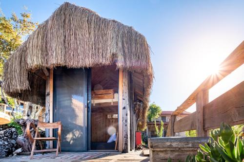 a small hut with a thatched roof and a chair at 3 Oda Kaş in Kas