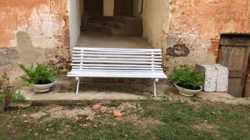 a white bench sitting in front of a building at I 5 Sensi Country in Brusnengo