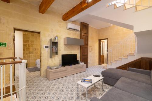 a living room with a couch and a tv at 16 lettings - charming character house in Birgu